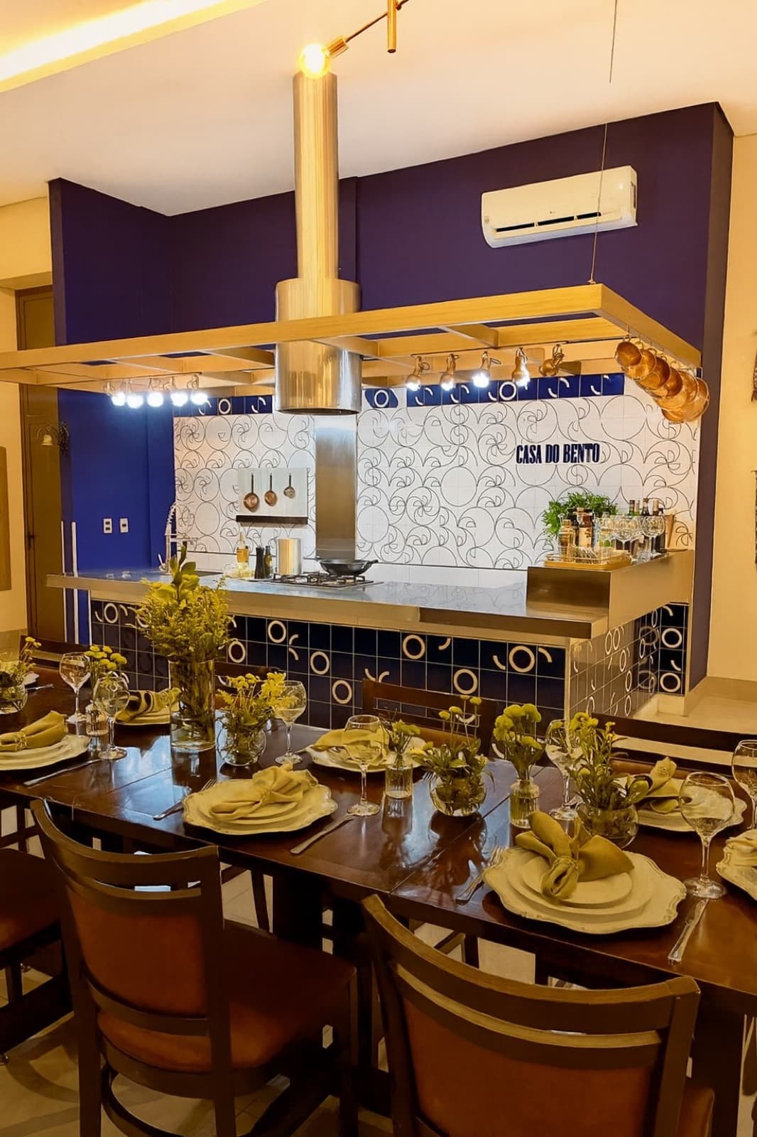 Detalhe de mesa posta decorada com louças e arranjos na Casa do Bento